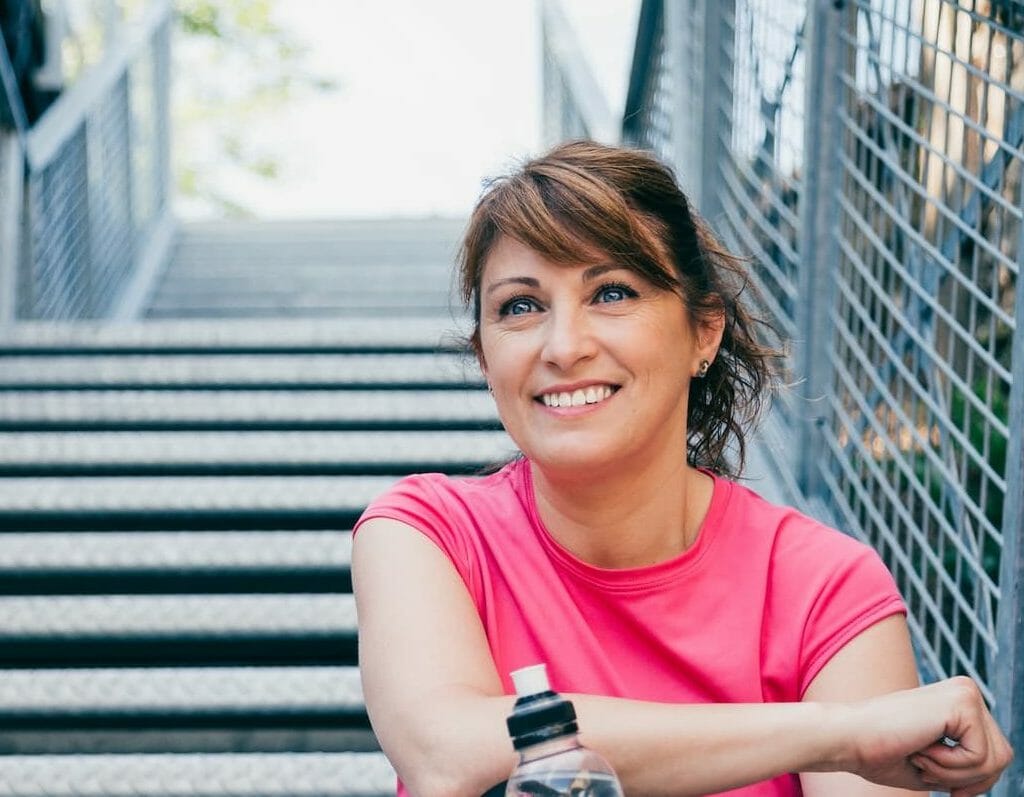 A woman smiling with a water bottle