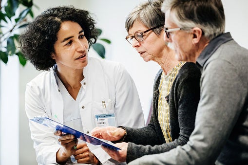 Physician discussing with two patients